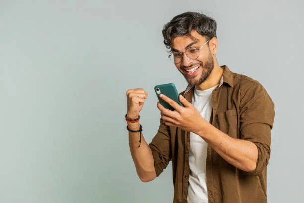 A young person celebrating a win while texting on their phone with "W" in text meaning displayed on screen
